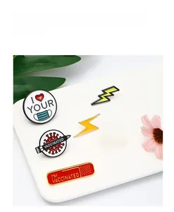 Macro shot of 5 colorful enamel lapel pins with vaccinated slogans on a white board