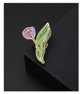 Detailed view of a purple tulip enamel brooch with green leaves on black gift box