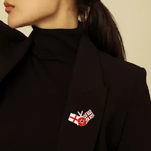Red poppy flower brooch with UK flags on a black suit lapel, elegant enamel jewelry
