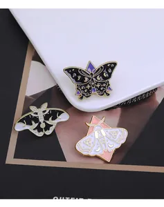 Détail de broches en émail colorées papillon et phalène aux motifs célestes