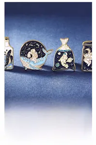 Detail showing four cosmic enamel pins with whales and astronauts on a blue background