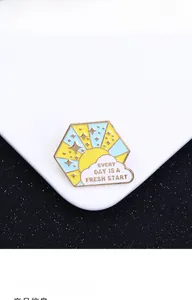 Detail of hexagon enamel pin with sun and Every Day Is A Fresh Start quote