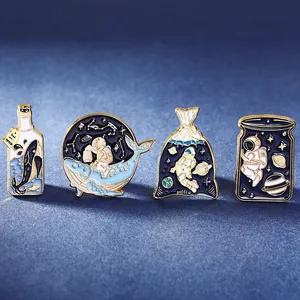 Space and whale themed enamel pin set with gold-plated edges on a starry blue background