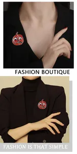 Close-up of red enamel pumpkin skull brooch pinned on a black suit jacket lapel