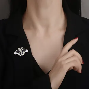 Broche papillon créative en émail avec détails dorés sur un revers de blazer noir rétro