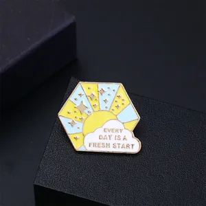 Hexagonal enamel brooch with daily fresh start quote and sun cloud design
