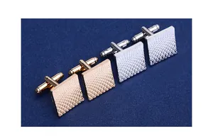 Detail of square cufflinks with textured grid pattern on navy blue fabric