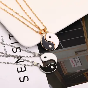 Gold and silver Yin Yang necklaces set with black and white pendant charms on white tray