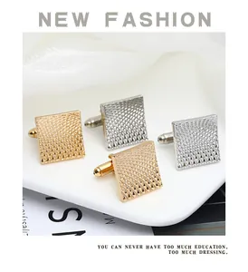 Detail of square cufflinks in gold and silver with textured grid pattern and metal finish