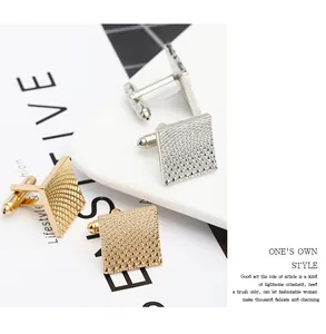 Close-up of square metal cufflinks featuring diamond grid texture in gold and silver