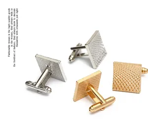 Detailed close-up of square metal cufflinks with textured grid pattern in gold and silver