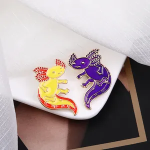 Cute cartoon axolotl enamel pins in yellow and purple on a white ceramic display stand
