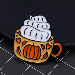Détail macro d'un pin's émaillé en tasse de café citrouille avec motif érable