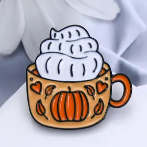 Détail du pin's émaillé en forme de tasse de café citrouille avec motifs de feuilles