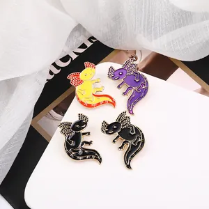 Cartoon axolotl enamel pins in multiple colors displayed on a white tray