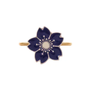 Macro shot of gold plated cherry blossom napkin ring with deep blue enamel details