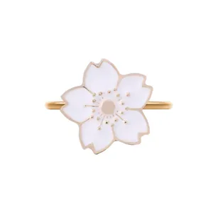 Macro shot of gold cherry blossom napkin ring with white enamel petals and pink accents