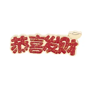 Macro shot of red enamel brooch with glitter gold 'Gong Xi Fa Cai' and ingot detail