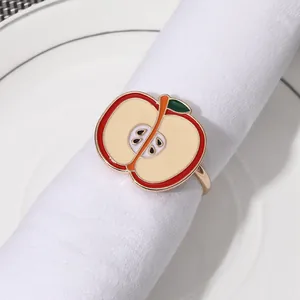 Detalle de servilletero con forma de manzana con esmalte rojo y base de metal dorado