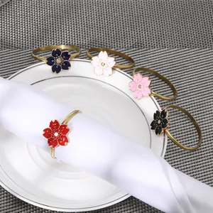 Golden flower napkin rings set in five colors on white cloth for elegant table decor