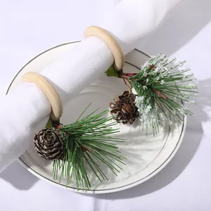 Servilleteros de piña con ramas de pino escarchadas para decoración de mesa festiva
