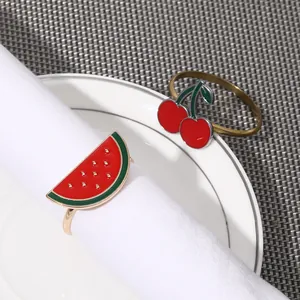 Detalle de servilleteros de frutas coloridas sobre una servilleta blanca elegante