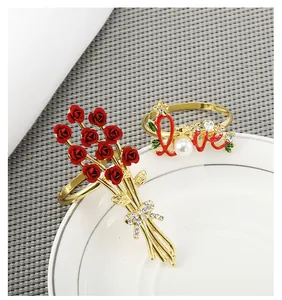 Nahaufnahme von Serviettenringen mit Rosen und Love-Motiv, Perlen und Kristallen