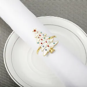 White enamel Christmas tree napkin ring with colorful rhinestones on a gold frame