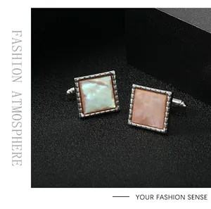 Detailed close-up of square men's cufflinks with mother of pearl inlay and silver frame
