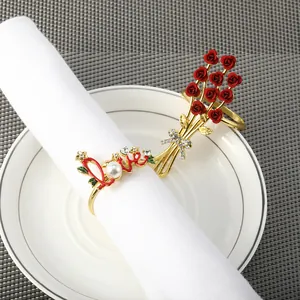 Detail von Serviettenringen mit Rose und Love-Motiv, Perlen und Strass auf dem Tisch