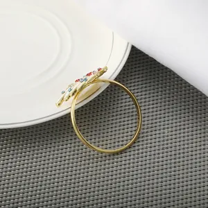 Detailed close-up of golden Christmas tree napkin ring with colorful crystal rhinestones