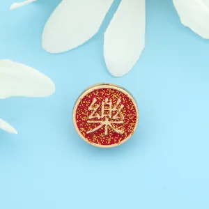 Detailed macro view of a red and gold Chinese character Le brooch with glitter finish