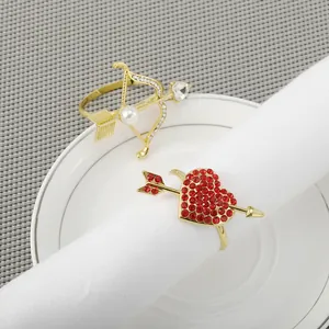 Elegante goldene Serviettenringe mit Perlenpfeil und rotem Strassherz für Tischdeko