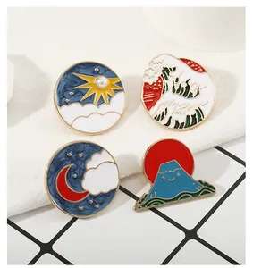 Vier Emaille-Anstecknadeln mit Motiven von Wellen, Berg Fuji und Mond auf Stoff