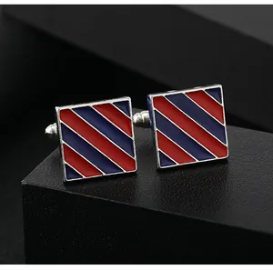 Detail of square silver cufflinks featuring diagonal red and blue enamel stripes