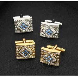 Macro detail of silver and gold square cufflinks with blue and white crystals