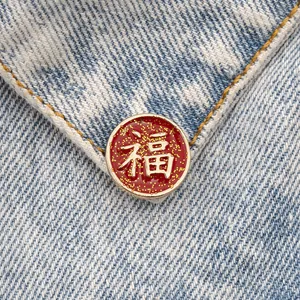 Red and gold traditional Fu character enamel brooch pinned on blue denim jacket