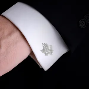 Polished silver maple leaf cufflinks on white shirt cuff for business formal wear