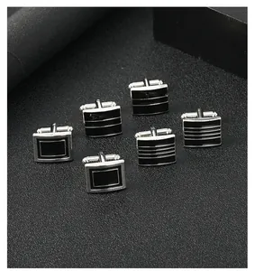 Detailed view of black enamel and silver metal cufflinks in three geometric patterns