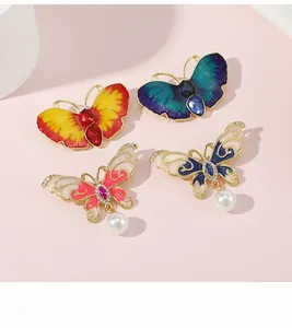 Détail macro de broches papillon avec émail coloré, strass en cristal et perles