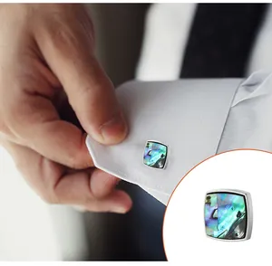 Macro detail of square abalone shell cufflinks on a white shirt sleeve for men