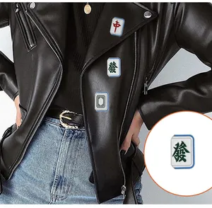 Detailed view of Mahjong-themed enamel pins pinned on a black leather jacket lapel