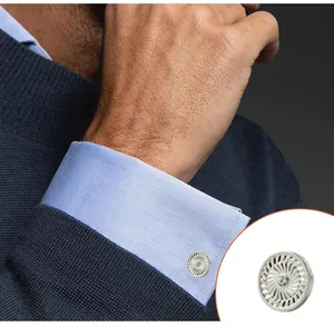 Macro detail of silver cufflinks with radial turbine pattern and center crystal on shirt