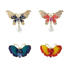 Broches papillon élégantes avec perles, ailes émaillées et strass étincelants