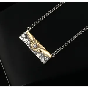 Macro detail of mountain relief pendant with sunburst zircon in two-tone gold and silver