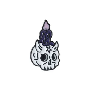 Gothic enamel pin featuring a white skull with a melting purple candle on top