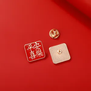 Broche carrée en émail rouge avec caractères dorés et fermoir papillon en métal