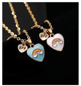 Vista macro di due collane BFF a forma di cuore con glitter arcobaleno e catene dorate