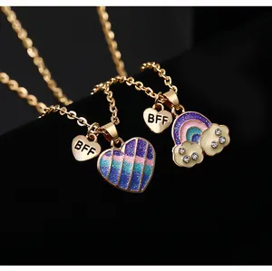 Dettaglio di collane dell'amicizia BFF con ciondoli arcobaleno glitterati e cuore su velluto
