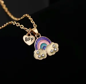 Dettaglio della collana BFF dorata con ciondolo arcobaleno glitterato, nuvole bianche e strass